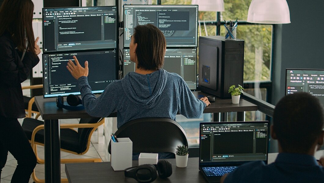 eine Frau, die vor einem Computerbildschirm steht